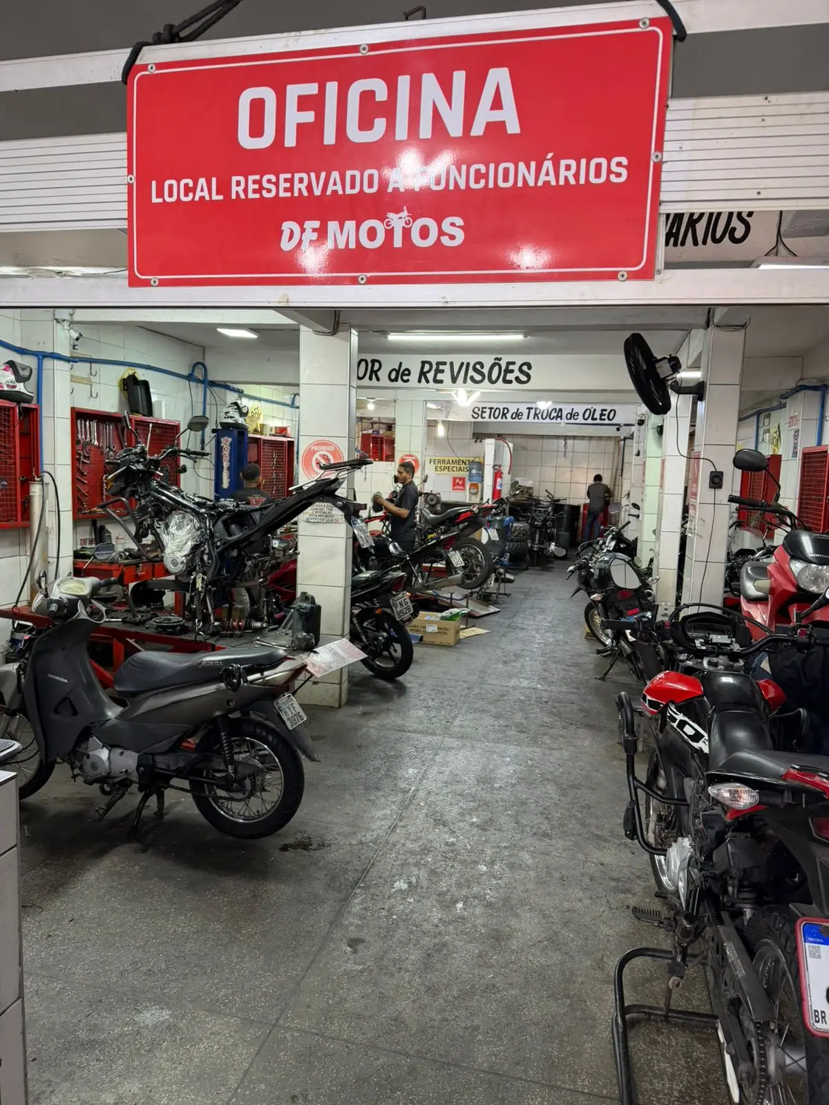 Placa Oficina, local reservado a funcionários, DF Motos, com setor de revisões e setor de troca de óleo ao fundo